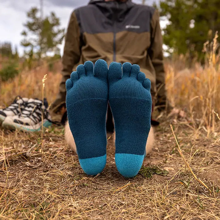 Injinji Toe Socks - Trail Midweight - soles up, seated in the field