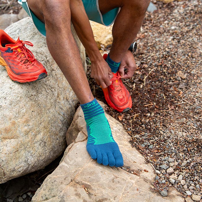 Injinji Toe Socks - Ultra Run Mini Crew - Poseidon - foot on rock beside a trail shoe