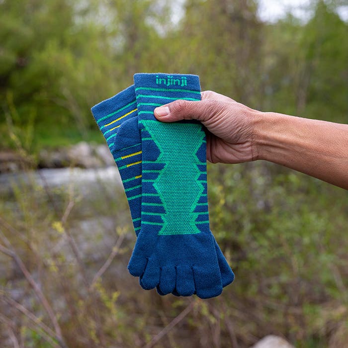 Injinji Toe Socks - Ultra Run Mini Crew - Poseidon - pulling the sock on by a creek