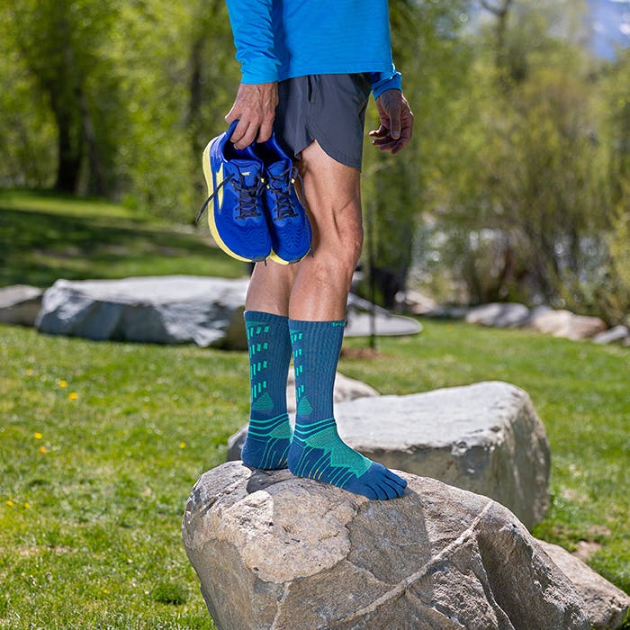 Injinji Toe Socks - Ultra Run Crew - Poseidon - standing beside a boulder